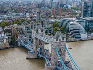 Stunning aerial view of Tower Bridge in London, spanning the River Thames with the city skyline in the background &mdash; blending historic architecture and modern urban beauty. London Bridge