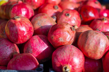 Red ripe pomegranates in a container. bright background, pomegranates close-up
