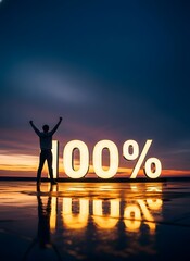 Silhouette of a person celebrating next to illuminated 100 percent sign on a beach at sunset