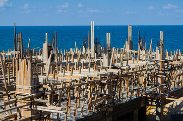 Coastal construction site with ocean view shows progress on new building project, perfect for real estate or architectural designs near the water