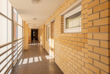 Sunny Corridor With Yellow Brick Walls and Bright Windows