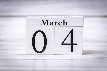 Wooden calendar showing March 04, symbolizing the transition into spring. Ideal for seasonal concepts, planning, or time management themes.