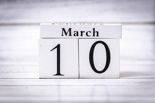 March 10 displayed on vintage wooden calendar blocks against a light wooden background, symbolizing the arrival of spring and daily life organization. Unique date presentation.