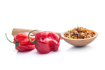 Red chili peppers flakes. Milled spicy peppers and habanero isolated on white background.