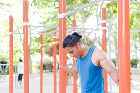 Venezuelan Latin man athlete training with determination in calisthenics park - Powered by Adobe
