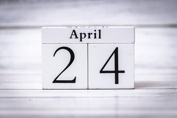 A white wooden calendar displaying the date April 24. The clean and minimalist design adds a modern...