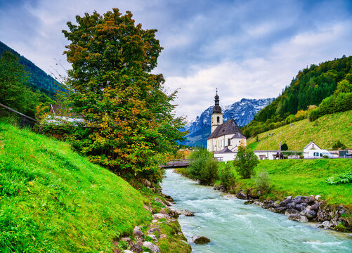 Wide angle shot of Parish Church of St. Sebastian and the flowing Ramsauer Ache, Germany