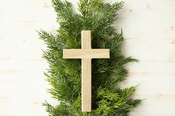 Cross on evergreen branch on white