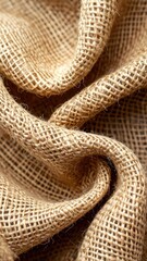 A macro shot of swirled, coarse, natural-fiber burlap fabric in soft folds