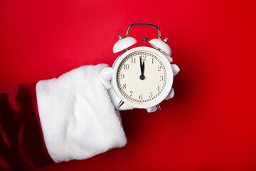 Santa Claus with alarm clock on red background, closeup. New Year greeting card