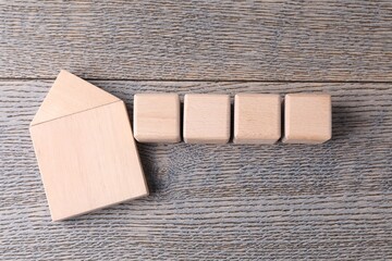 Blank cubes and house model on wooden table, flat lay. Mockup for design
