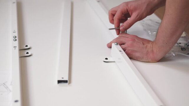 A person is assembling a white shelf using metal parts and a tool. Step-by-step actions show how to fit pieces together effectively for home organization.