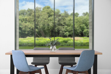 Table and chairs near window in room. Interior design