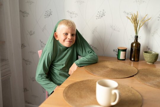 Boy in playful pose at dining table