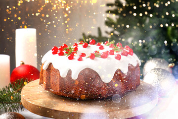 Tasty Christmas cake with red currants, fir branches, candles and festive balls on table. Bokeh lights