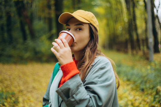 Girl enjoying coffee on an autumn walk in the park