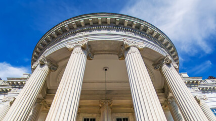neoclassical building with marble columns in Washington, D.C., under a blue sky. Wide-angle shot.