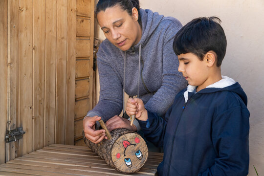 Mother and child decorating a log in the Tio de Nadal Tradition