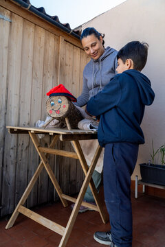 A mother and son engage in the Catalonian Tio de Nadal tradition