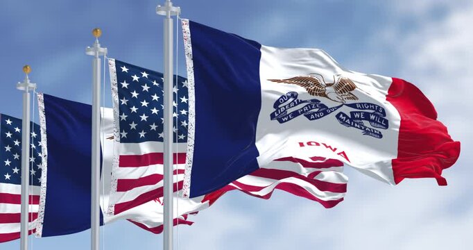Iowa state flag waving in the wind with the US flag on a clear day