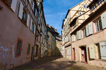 Fototapeta premium colmar Charming narrow street view of traditional half-timbered buildings in a historic European town during a clear day showcasing architectural heritage and inviting atmosphere