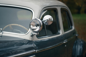 Close-up of a vintage grey car showing classic design details and chrome elements. The image...