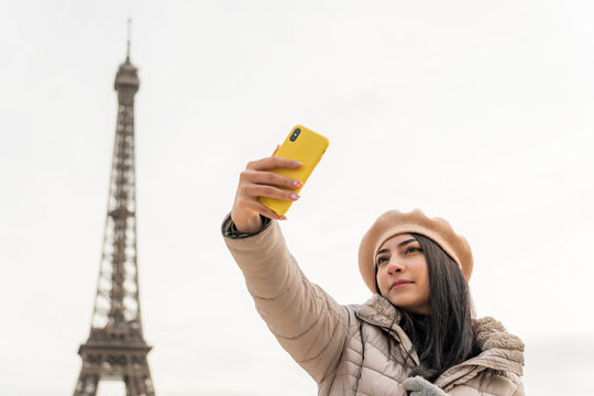 Girl taking selfie in Paris during winter
