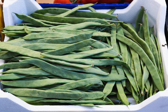 Fresh green beans in a white market crate