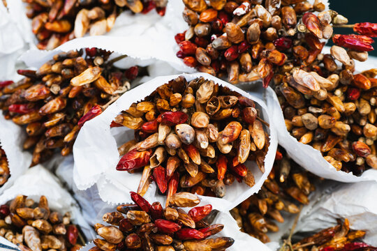 Dried chili peppers in paper bags showcase vibrant hues