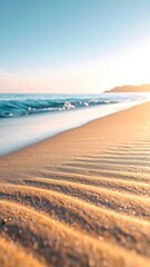 Golden sand ripples on a serene beach at sunrise with calm ocean waves