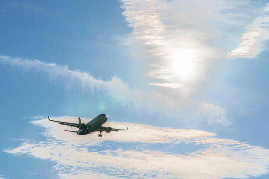 Airplane soaring against a bright sunny sky