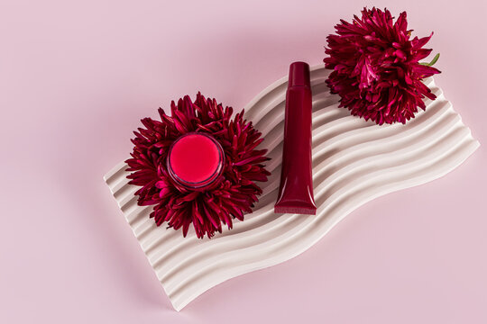 Lip balm with aster flower on decorative plate