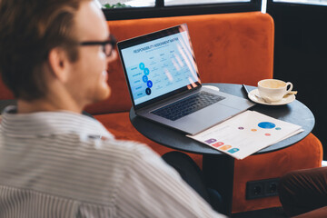 Laptop screen displays responsibility assignment matrix as startup team focuses on role...