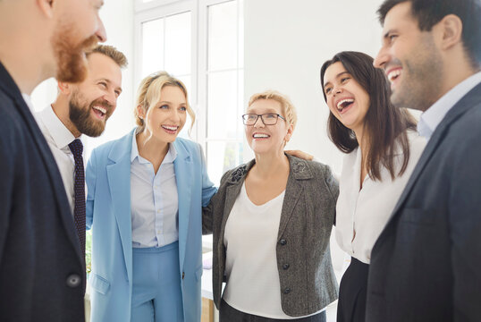Fototapeta Diverse common happy people group teambuilding gathered in circle hug at workplace office, share, psychological support, helping, plan strategy, interacting with sympathy on psychotherapy training