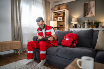 Obraz premium Male paramedic making home visit writing medical report