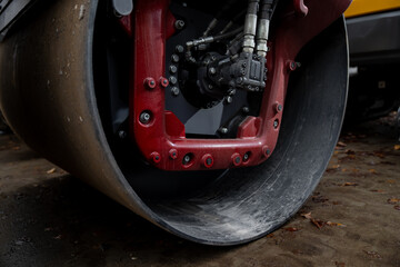 Industrial macro of heavy compaction roller drum and hydraulic components showing precision...