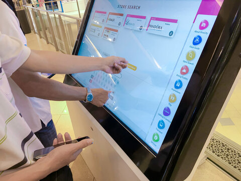 Kiosk Interface information control panel inside shopping mall - November 30, 2018,  A man is using the touchscreen interface kiosk to look up store information inside shopping mall