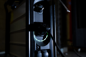 Industrial power outlet with illuminated green ring and plug inserted showing electrical energy...