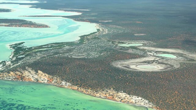 Drone-style perspective from airplane flying over Useless Loop salt fields and arid coastal landscape