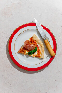 Slice of pizza with ham and fresh basil