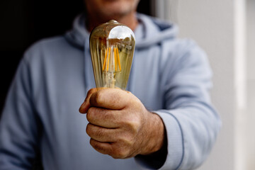 Man holding antique light bulb in focus