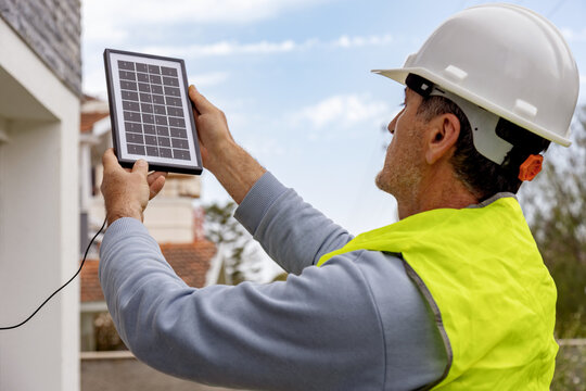 Man holding solar panel outdoors in sunlight