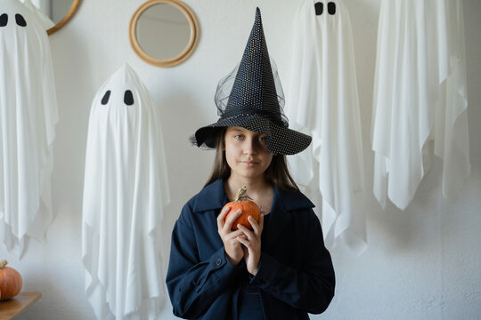 Halloween witch with ghosts and pumpkin in portrait