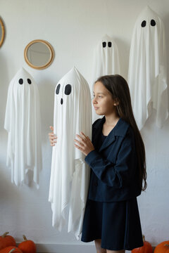 Halloween portrait featuring child with friendly ghosts