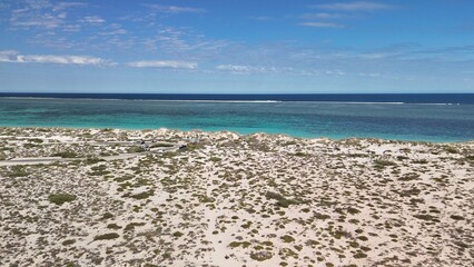 Panoramic aerial view of Turquoise Bay in WA with reef, waves, and tropical scenery