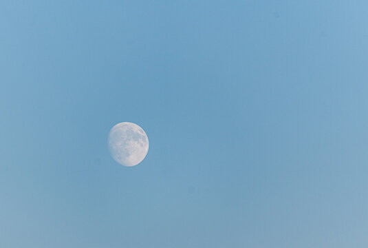 Moon in blue sky during daytime