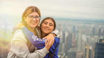 Fototapeta premium Friends embracing with Manhattan cityscape in the background captured from a high-rise building