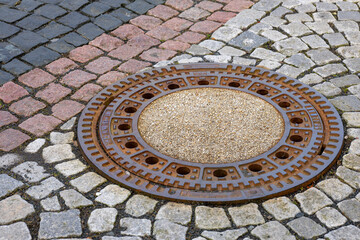 Manhole Cover on Cobblestone Pavement