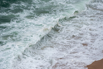 wave breaking on the beach in Nazar&eacute;, Portugal