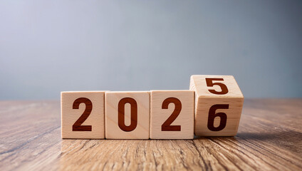 Wooden cubes showing transition from year 2025 to 2026 on wooden table. Concept of change, growth, future, and planning for new opportunities ahead.